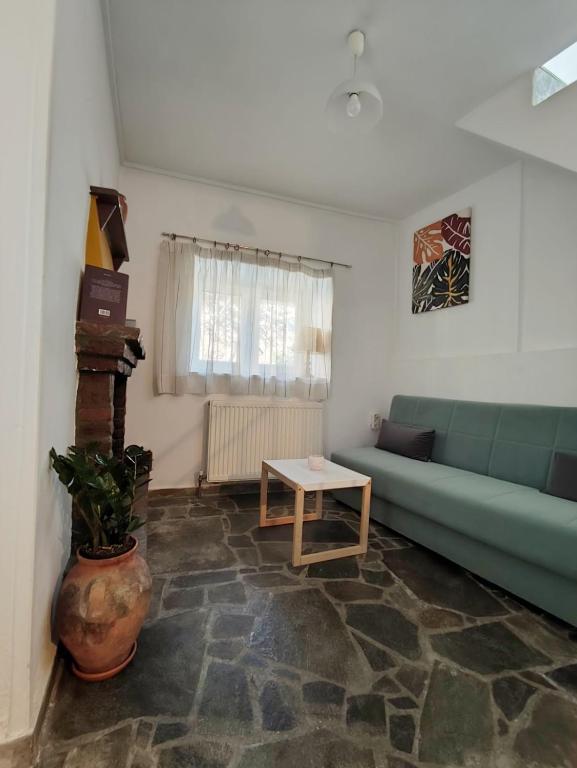 a living room with a green couch and a table at Traditional Stone House in Mantamádos