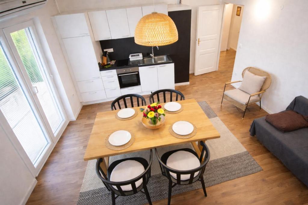 a kitchen and living room with a wooden table and chairs at Apartments Poldi in Bled