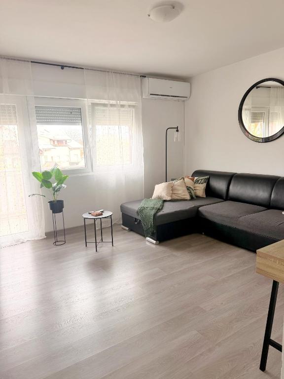 a living room with a black couch and a table at Bajkoviti kutak in Ogulin