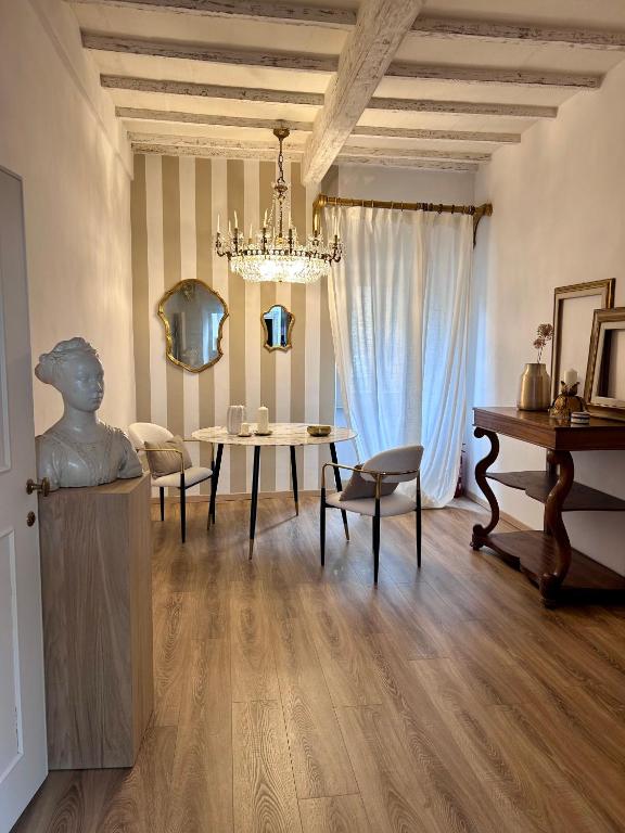 a living room with a table and a chandelier at Palazzo Calderini in Castiglion Fiorentino
