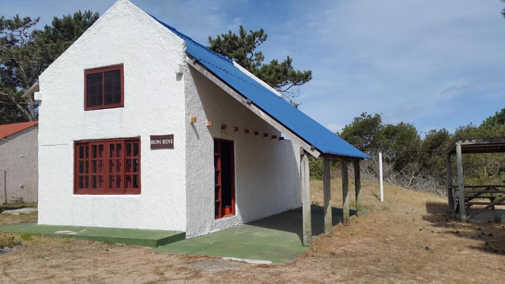 una pequeña casa blanca con techo azul en Bon Bini, en Punta del Diablo