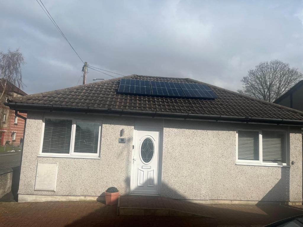 a house with solar panels on the roof at Cute Cottage Central Bathgate Inc Sofa Bed in Bathgate