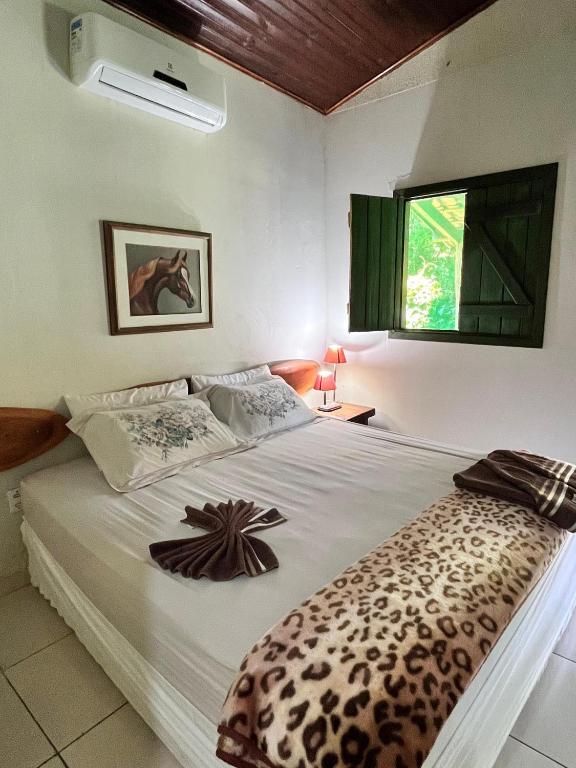 a bedroom with a bed with a leopard blanket on it at Eco Charme da Bodoquena in Bodoquena
