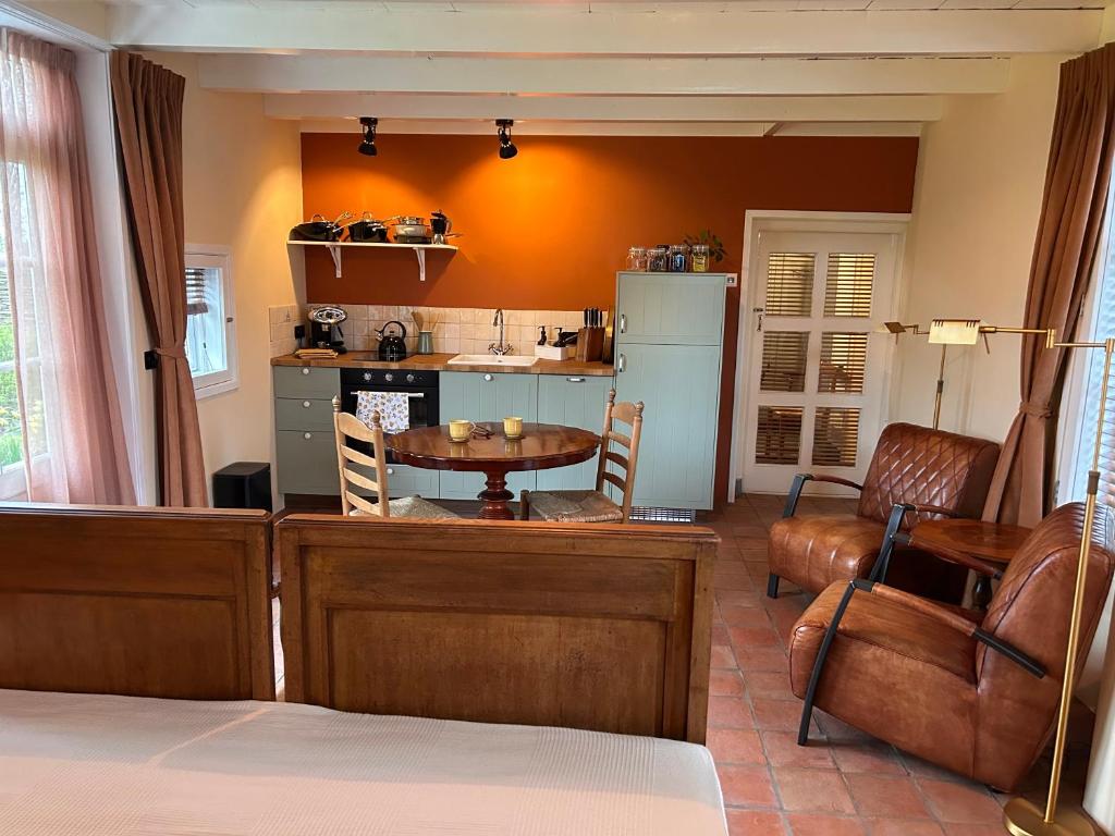 a living room with a table and a kitchen at Studio 1772 in Kamperland