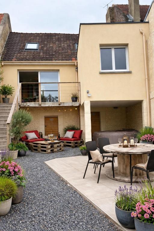 a patio with a table and chairs and a house at Gite Le Long de l'eau in Long