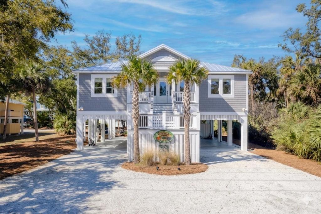 a house with palm trees in front of it at Jungle House-Heated Pool-Pet Friendly-Luxury in Edisto Island