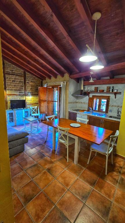 a kitchen and dining room with a wooden table and chairs at APARTAMENTOS La Colmena APT- 2 - AT-CC-00248 in Gata