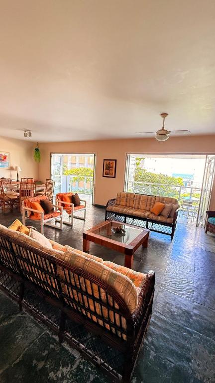 a living room with couches and tables in a room at Varanda do Mar Pitangueiras - 4 Quartos - Até 10 Pessoas - 2 Vagas in Guarujá