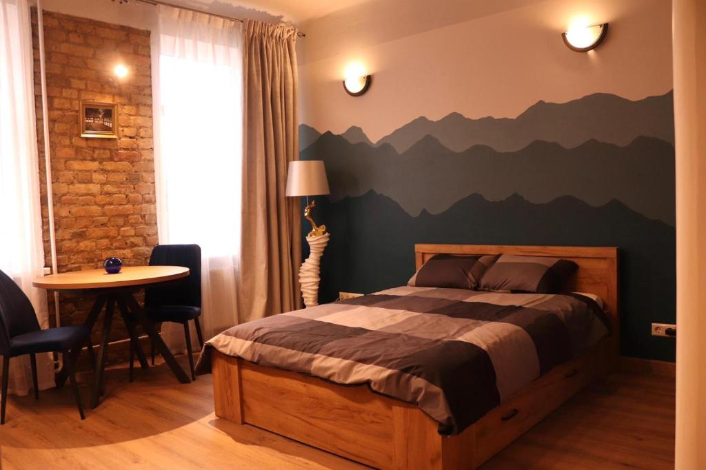 a bedroom with a bed with a mountain mural on the wall at Cozy Alauksta apartment in Riga