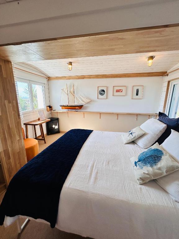 a bedroom with a large bed in a room at "La Cabine" côté mer et côté jardin à la VILLA PLEIN VENT in Barneville-Carteret