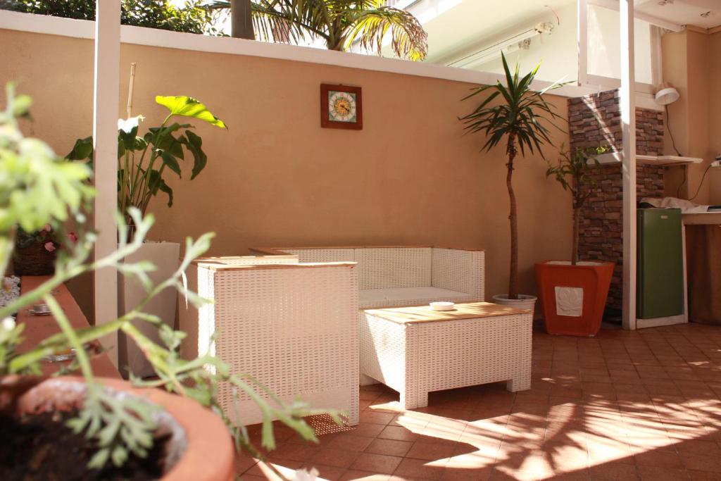 a patio with white wicker chairs and a table at B&B Raggi d'Ischia - nuova gestione 2026 in Casamicciola Terme
