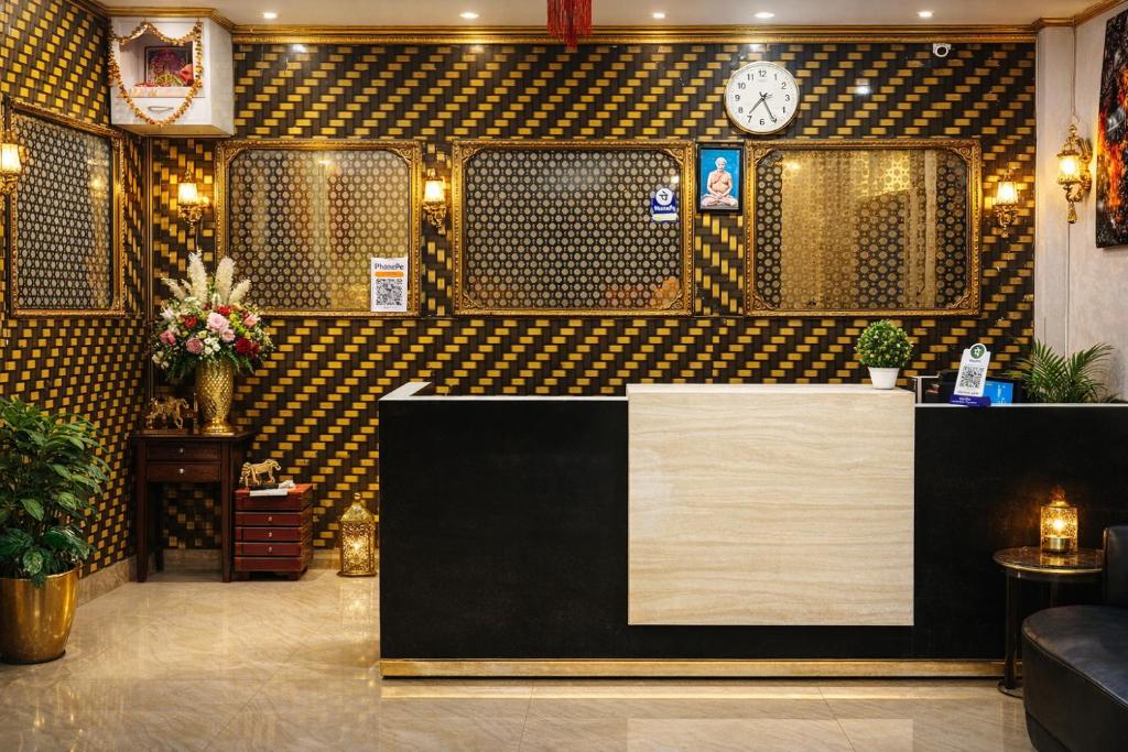 a restaurant with a counter and a clock on the wall at Hotel Sundaram in Deoghar