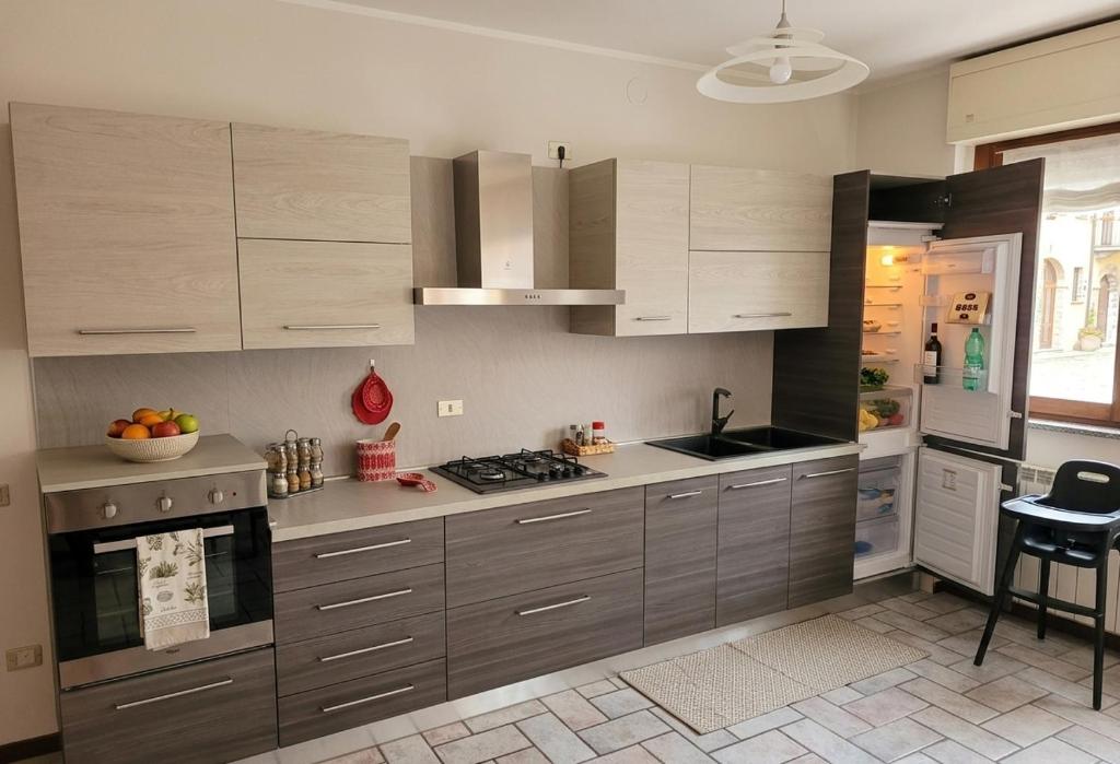 a kitchen with gray cabinets and a stove top oven at a casa di BIRI in Trezzo sullʼAdda