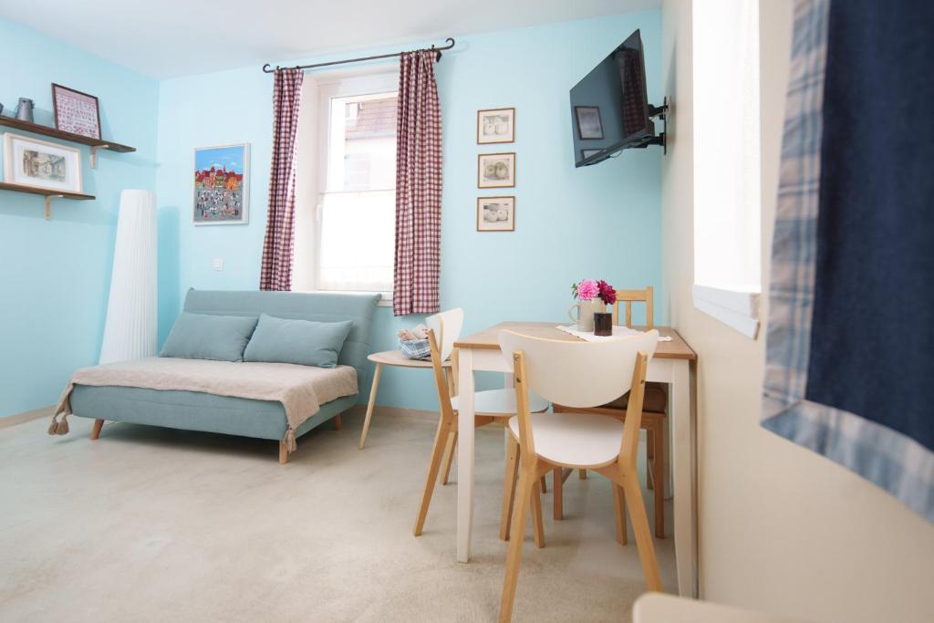 a living room with a table and a couch at Les Jardins de Colmar in Herrlisheim-près-Colmar