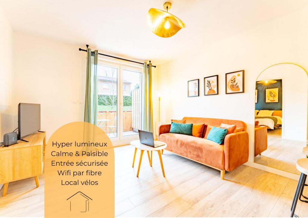 a living room with an orange couch and a tv at La bastide de Montech in Montech