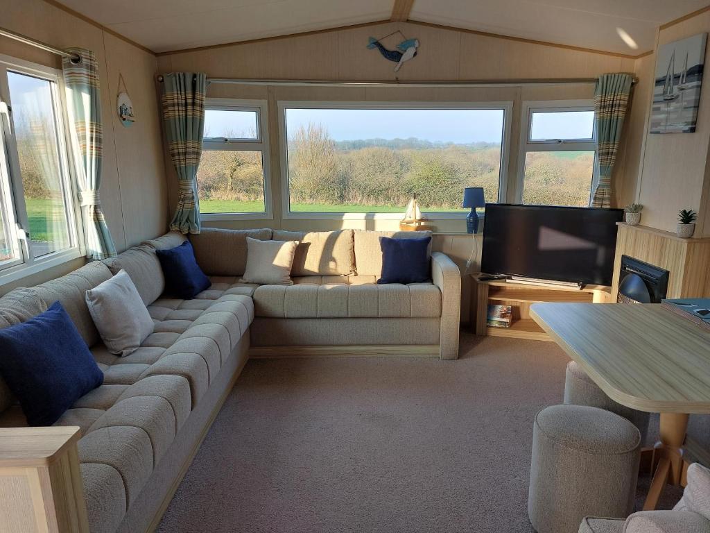 a living room with a couch and a flat screen tv at Gateway to Cornwall in St Austell