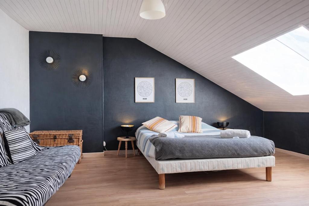 a attic bedroom with two beds and a couch at Le Petit Loft Vosgien -Escapade nature & cosy in Cornimont