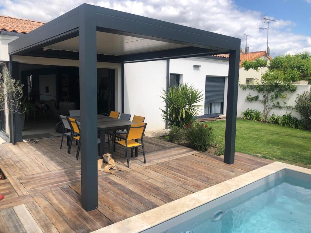 a pavilion with a table and chairs and a pool at Villa d Architecte Moderne spa et piscine in Niort