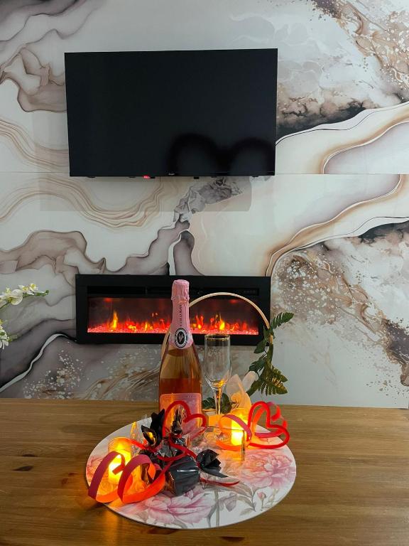 a bottle of wine on a table in front of a fireplace at Ala Pa cá in Miajadas