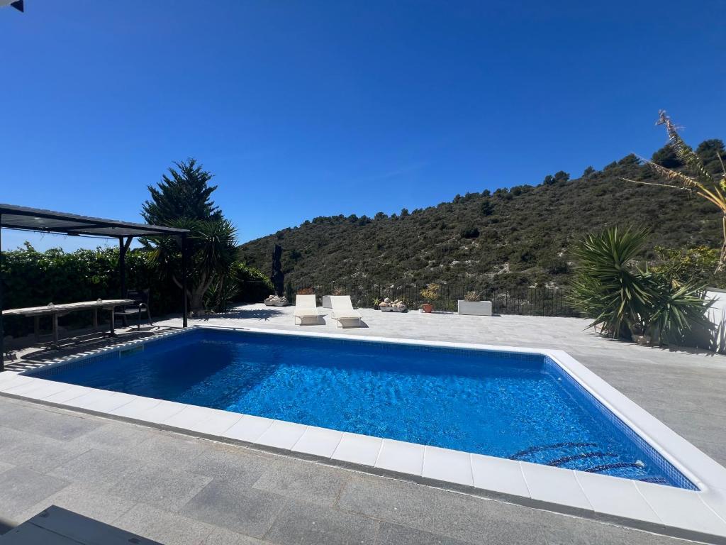 a swimming pool in a yard with a mountain in the background at Estudio nuevo zen in Calafell