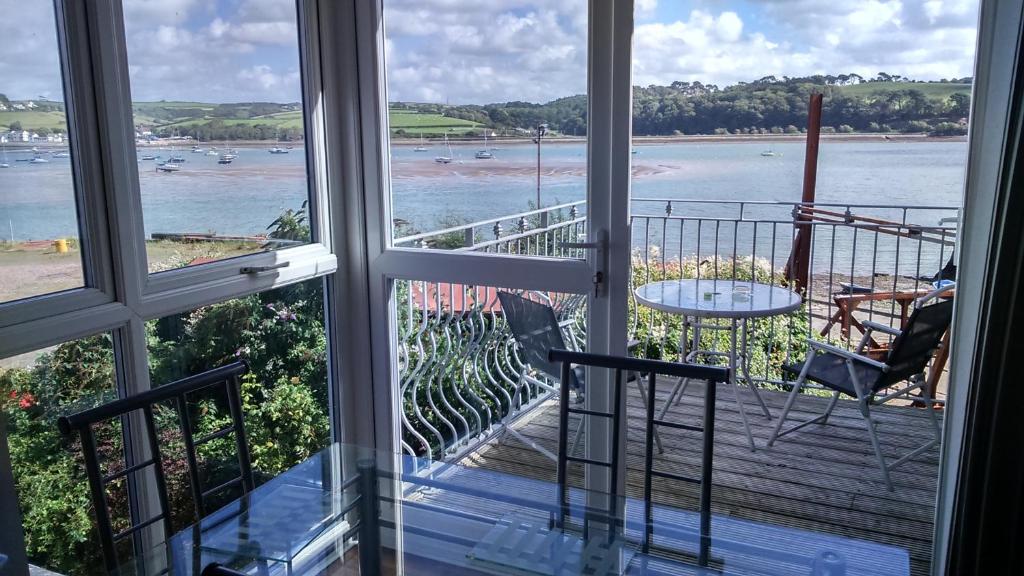 a balcony with a view of the beach and a table and chairs at The Boat Yard in Appledore