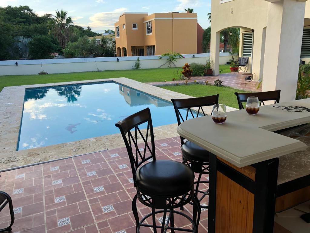a patio with a table and chairs next to a swimming pool at A Private Paradise by the Rainforest in Luquillo