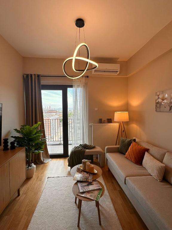 a living room with a couch and a large window at EVA Premium Luxury Apartments - Limak Diamond Residence in Skopje
