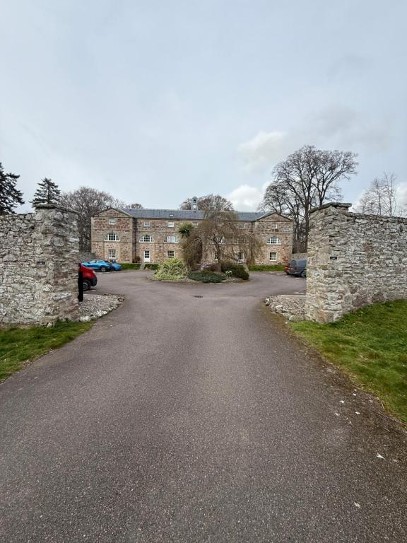 an empty road in front of a brick building at Culloden Stables 4 in Inverness