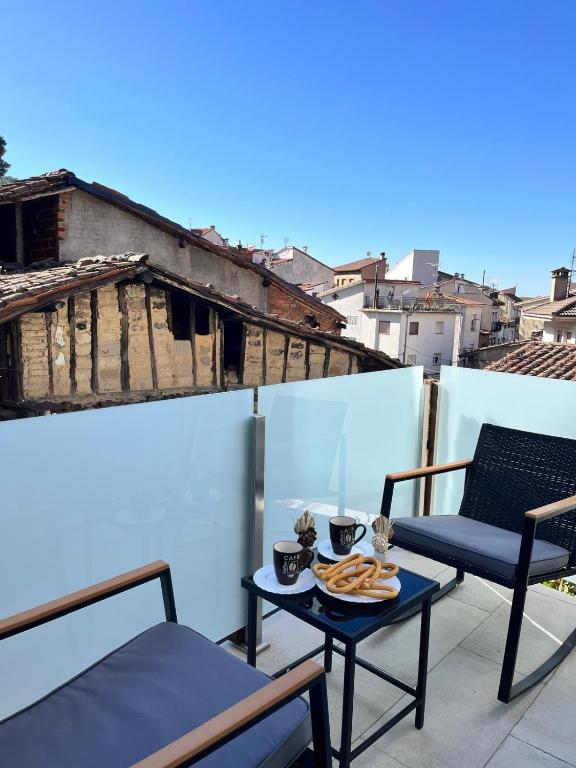 a balcony with a table and chairs on a roof at Mabel House Suites in Mijares