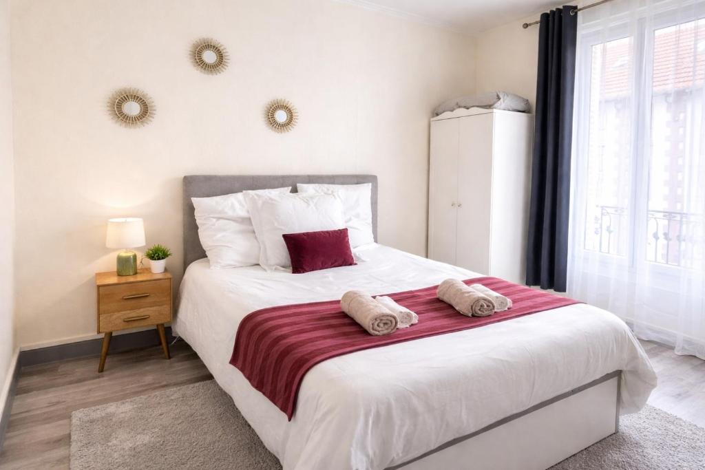 a bedroom with a large bed with two towels on it at T2 cosy & calme - Gare à 1 min accès direct Paris & CDG in Aulnay-sous-Bois