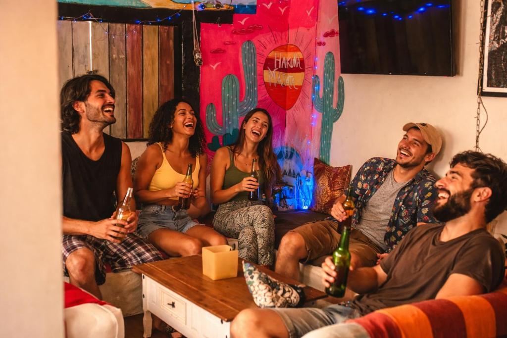 a group of people sitting on a couch with drinks at Raizes Bed and Beach Buzios in Búzios