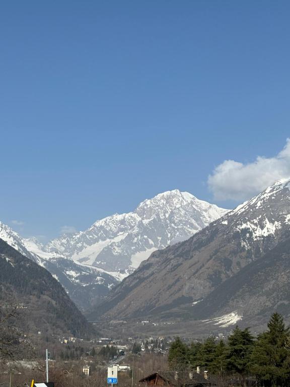 a snow covered mountain range with a town in the foreground at Casa parrocchiale La Salle in La Salle