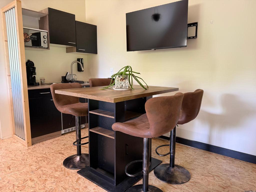 a kitchen with a wooden table and stools at Le Studio d'Instant Nature in Alexain