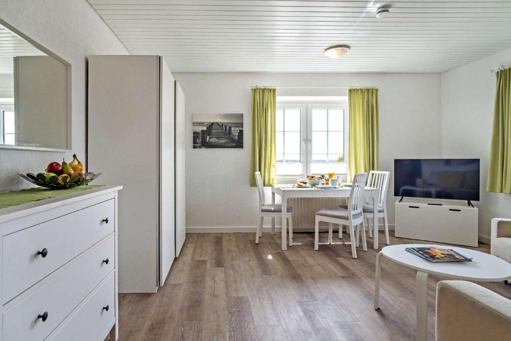 a living room with a table and a dining room at Knusthof Lafrenz - Küstenblick in Fehmarn