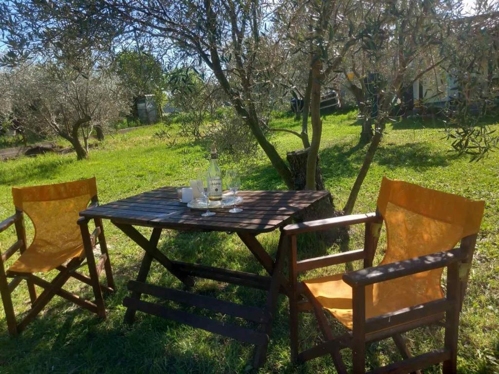 a picnic table with two chairs and a table with glasses on it at Κτήμα Ανάσες Ζωής- Ευγενία Σγούρα in Epanomi