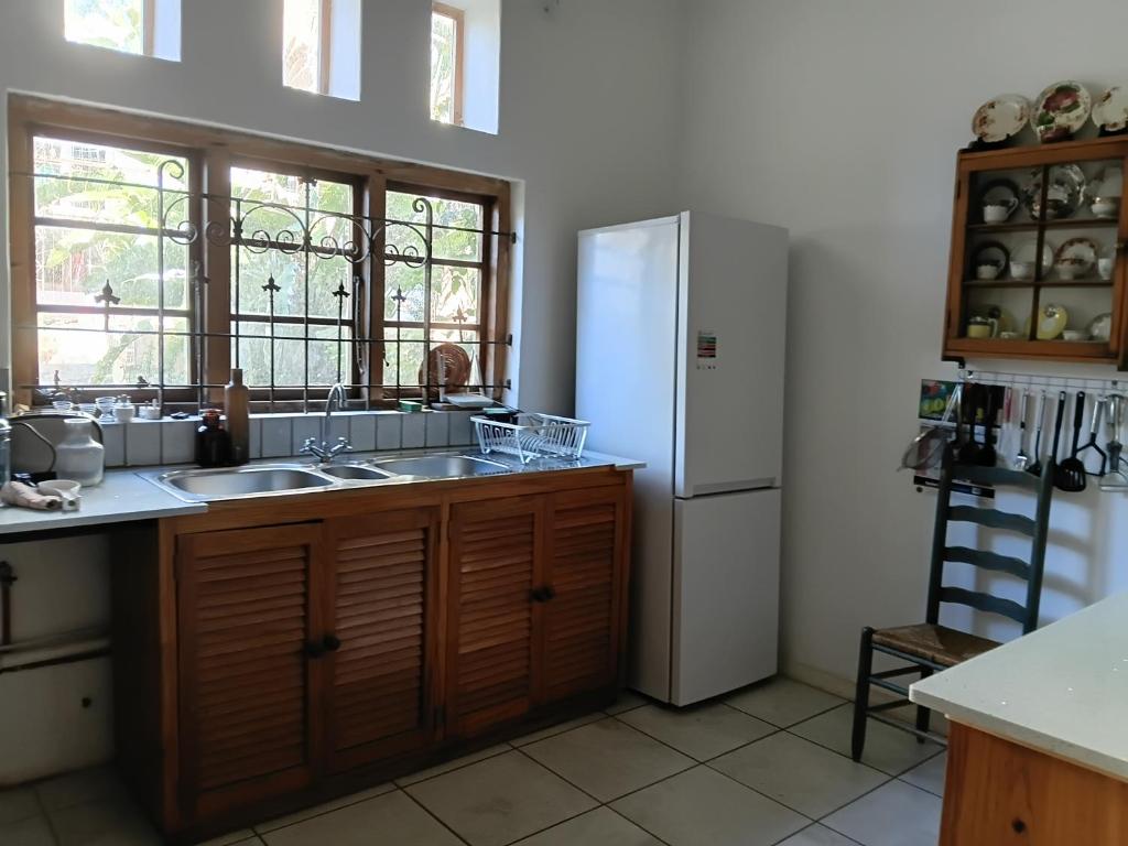 a kitchen with a sink and a refrigerator at Natalie's Garden Cottage, in McGregor