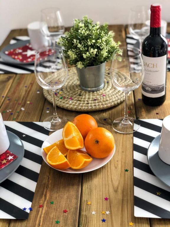a plate of oranges on a table with wine glasses at CHiC APARTMENT in Tossa de Mar