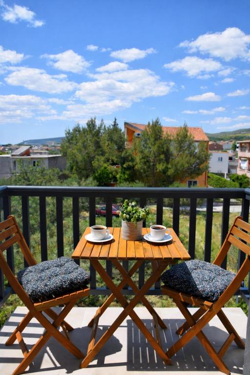 a wooden table and two chairs on a balcony at GUESTHOUSE Kastel Novi in Kaštela
