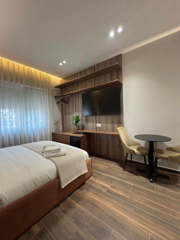 a bedroom with a bed and a table and a television at Elios Near Centre Apartment in Tirana