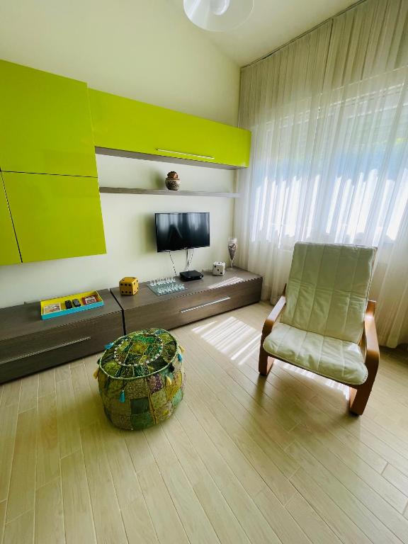 a living room with a chair and a television at Xerxe's House in Varenna