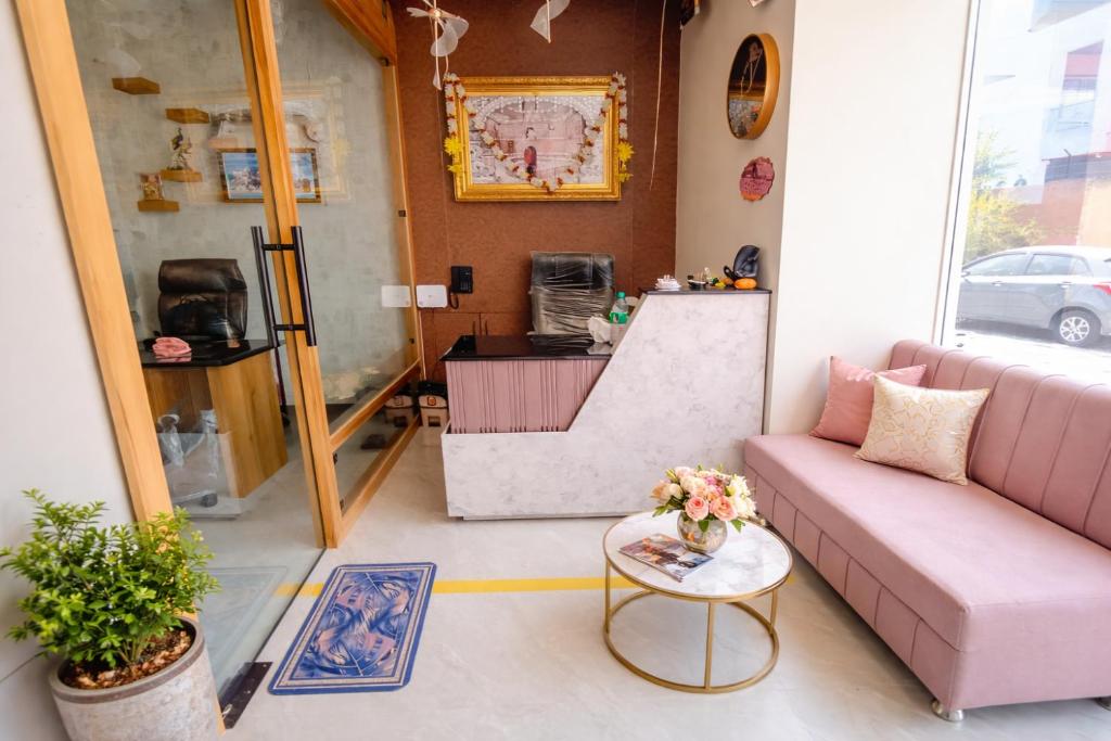a living room with a pink couch and a table at Rukkmannie Holiday Inn in Ujjain