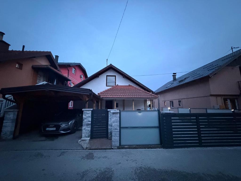 a car parked in a parking lot next to a house at Apartman Tajchi in Sarajevo