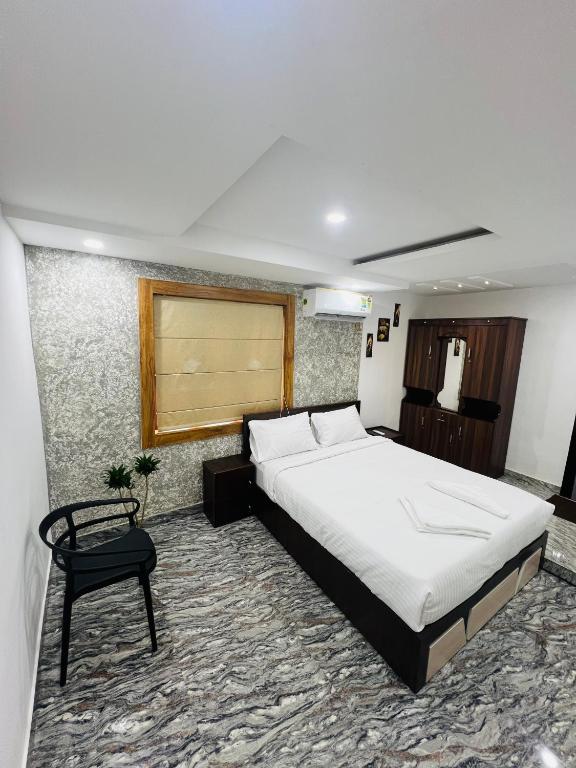 a bedroom with a large bed and a chair at Elowen Villa in Mananthavady