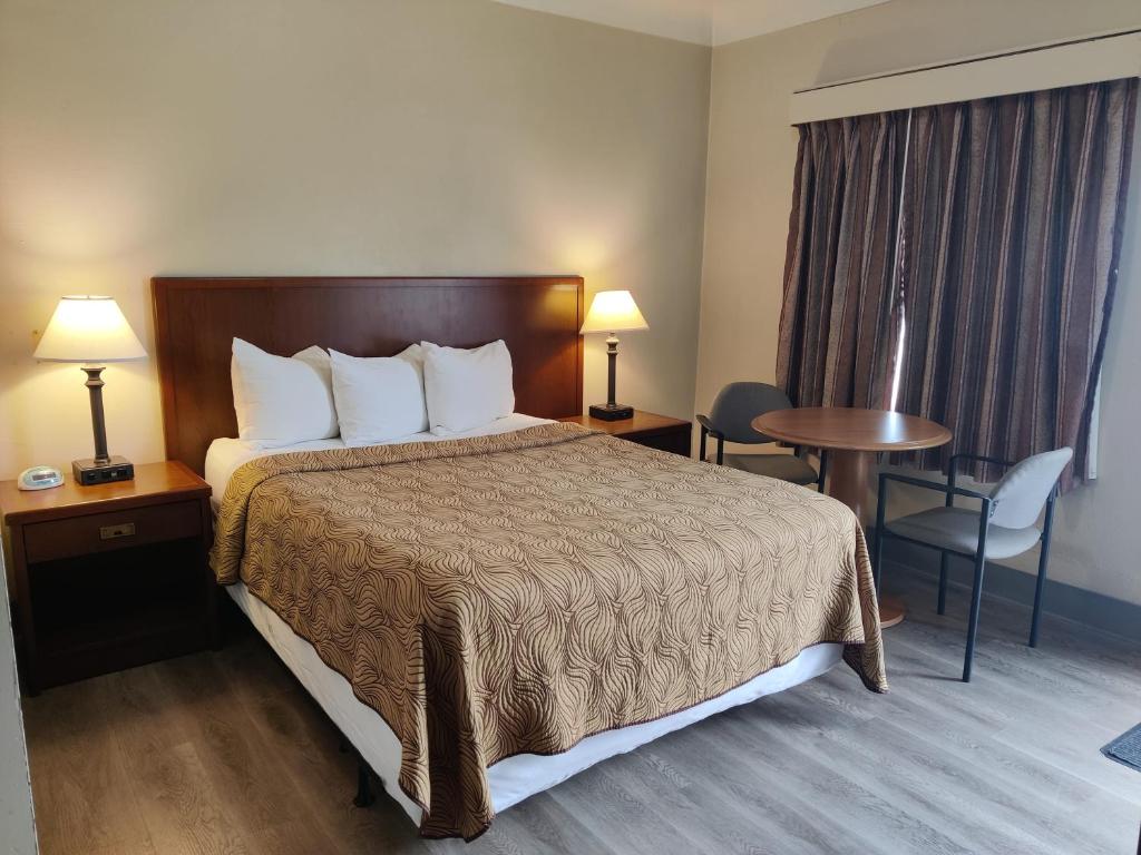 a hotel room with a bed and a table and chairs at Knights Inn London Ontario in London