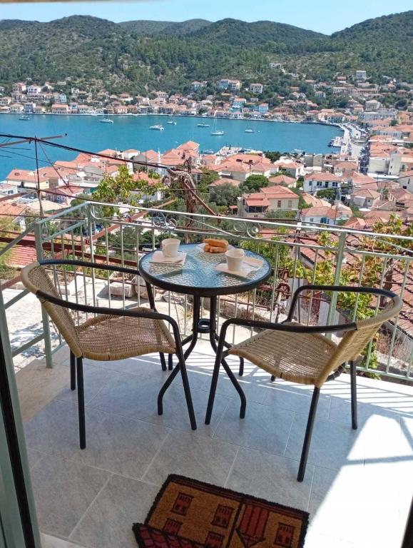 a table and chairs on a balcony with a view at Perioptron Guesthouse Ithaca in Vathi