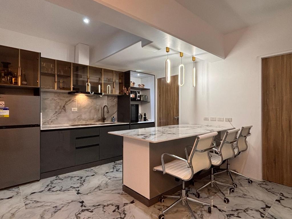 a kitchen with a counter and some chairs in it at MeCasa in Mactan Island