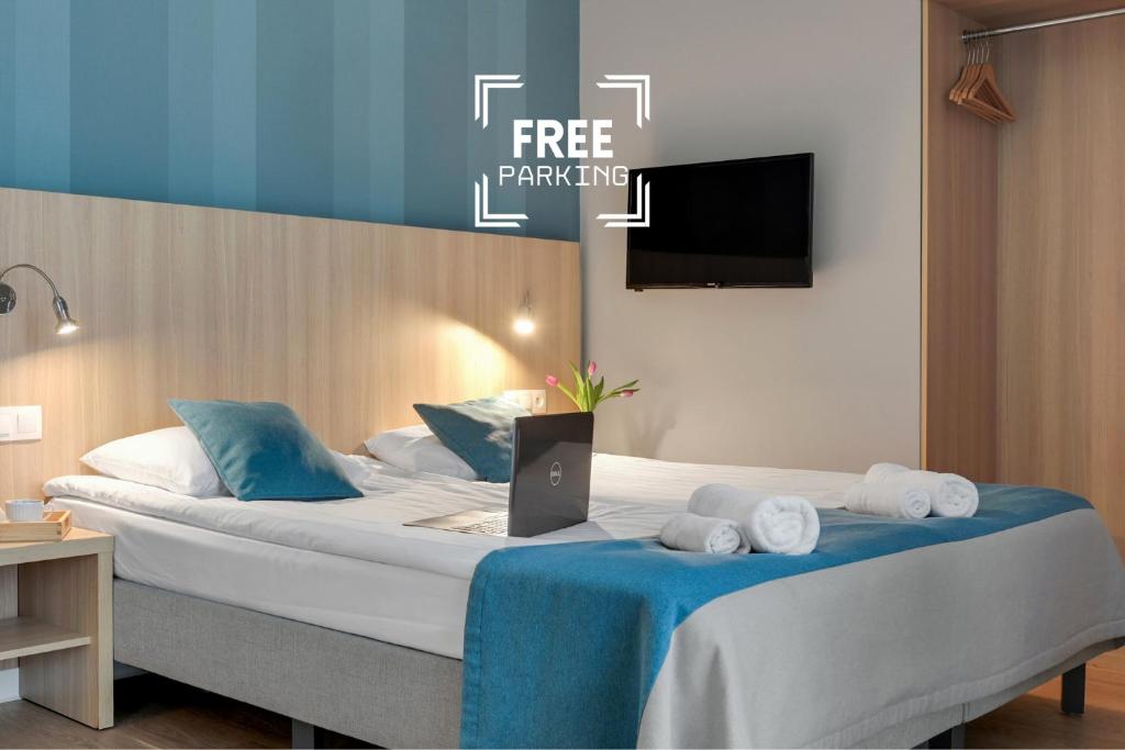 a hotel room with a bed with a laptop on it at Hotel Zatoka in Gdańsk