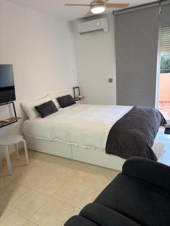 a bedroom with a bed and a tv and a couch at Taína La Encina in Vícar