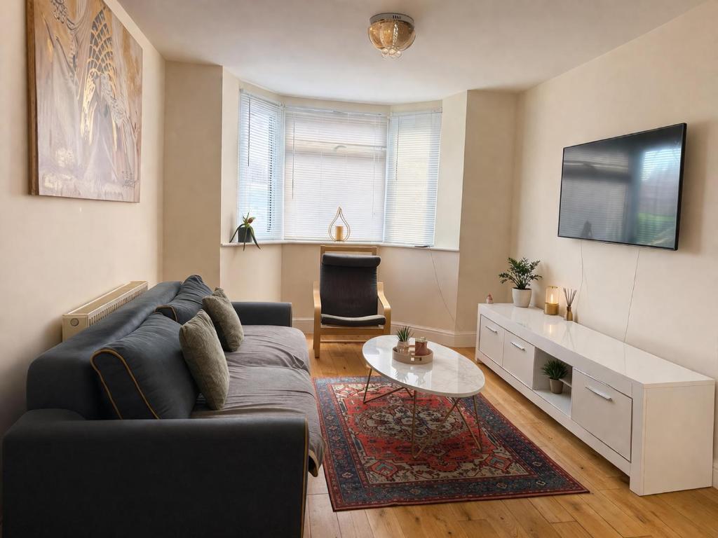 a living room with a couch and a table at London Heathrow Accommodation in Hillingdon