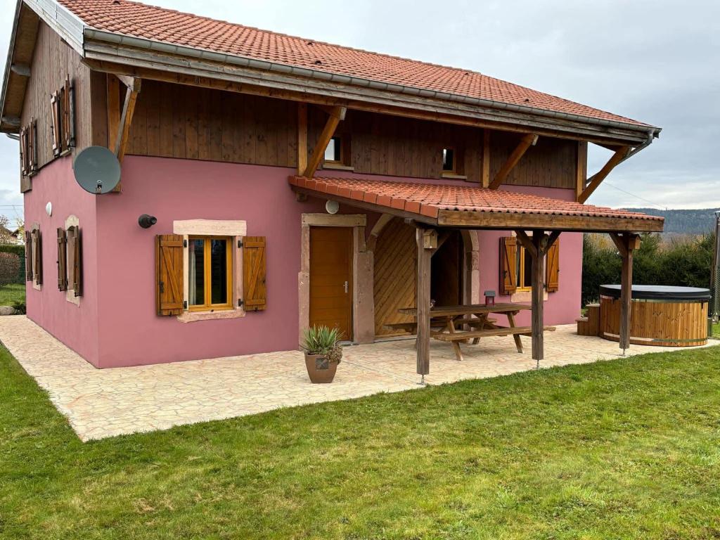 a small pink house with a wooden roof at Le ptit Sabot in Corcieux